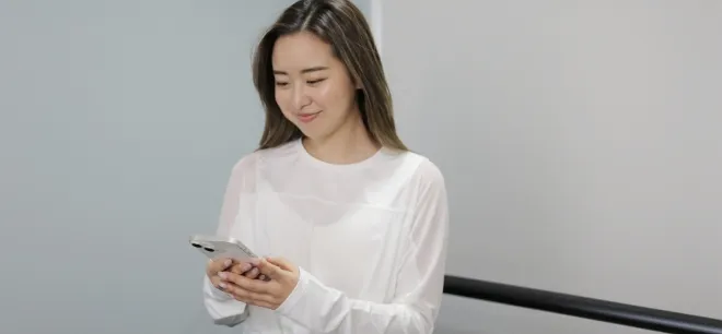 スマホを見ながら微笑む女性